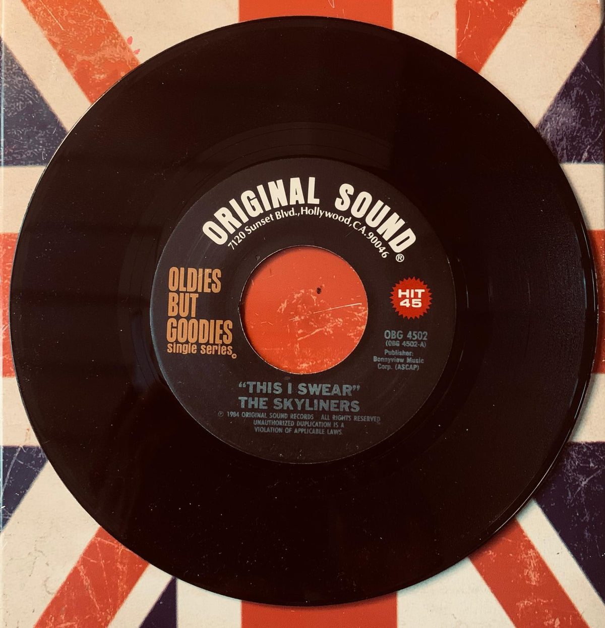 Black vinyl record with red center label showing the song this i swear by the skyliners from original 45t vinyl