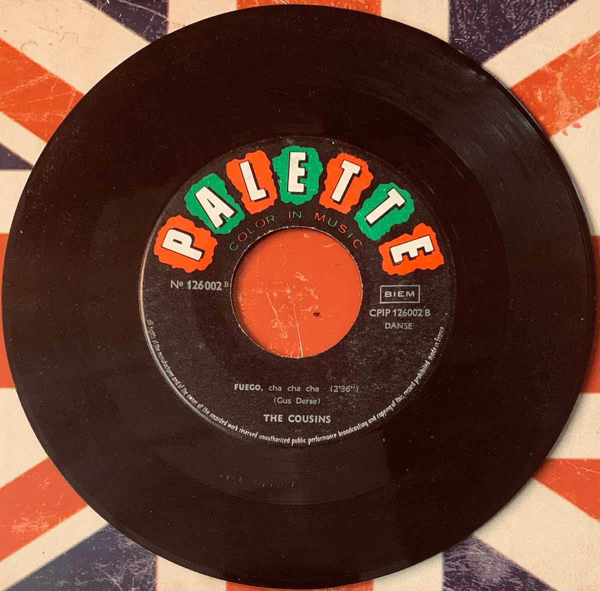 Black vinyl record with colorful palette label in orange and green lettering featuring fuego by the cousins from original 45t vinyl