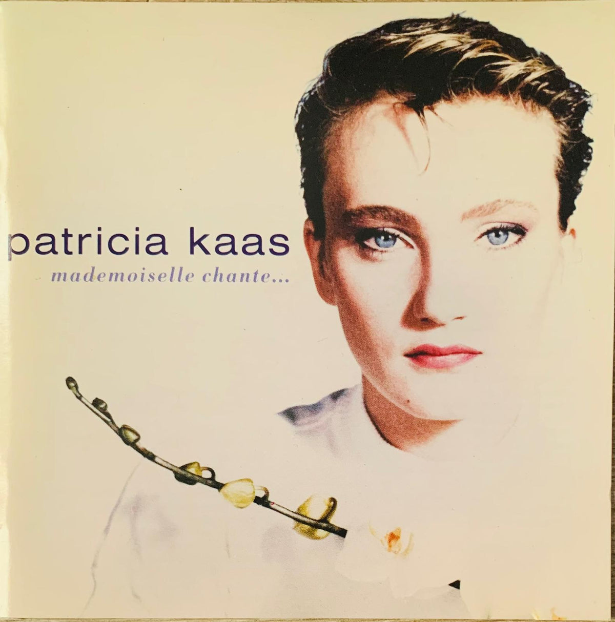 Patricia Kaas original CD mademoiselle chante album cover portrait with short dark hair and blue eyes on cream background