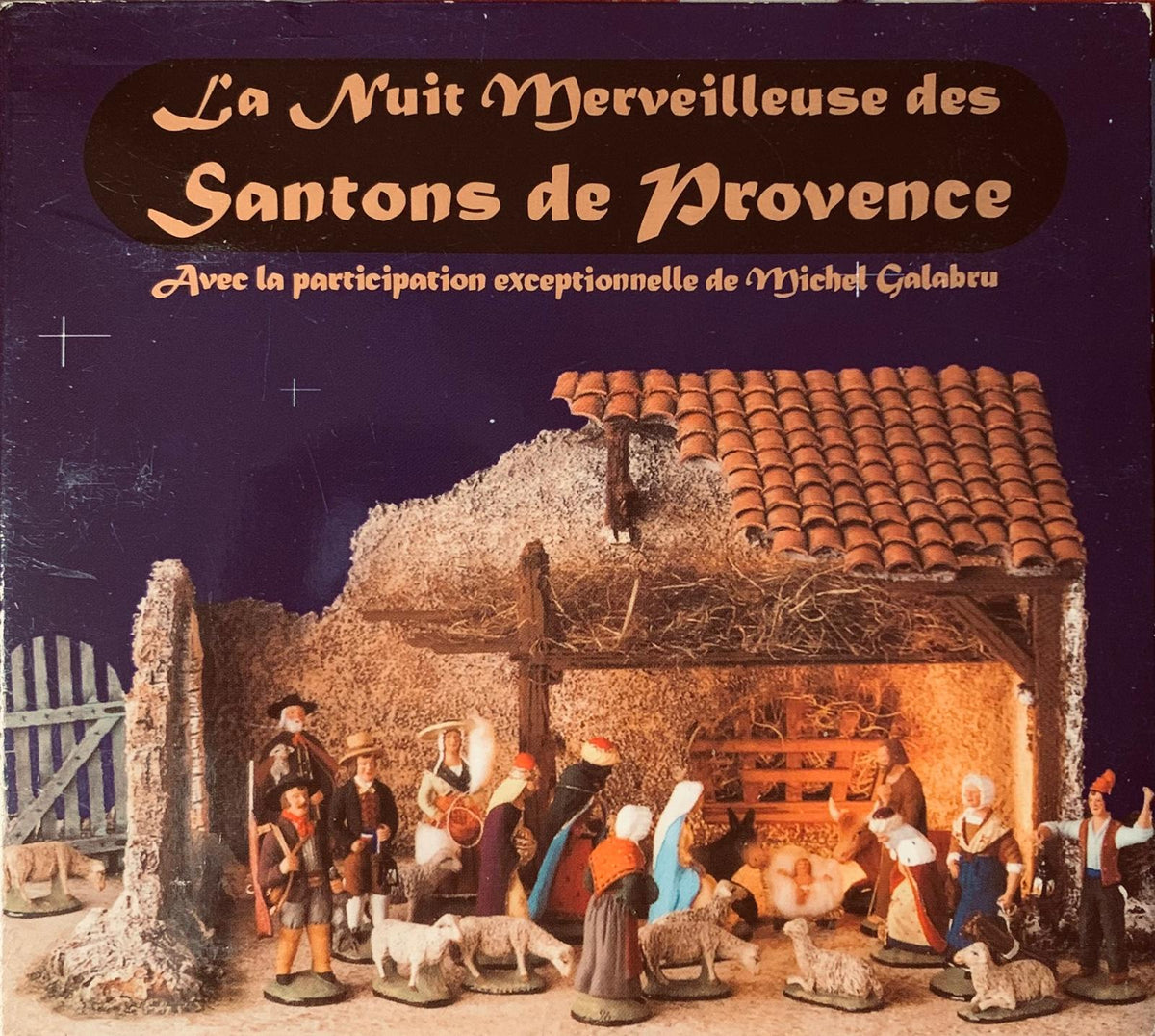 A detailed miniature nativity scene with painted provençal figurines in a rustic stable on the cd cover of michel galabru’s la nuit merveilleuse des santons de provence