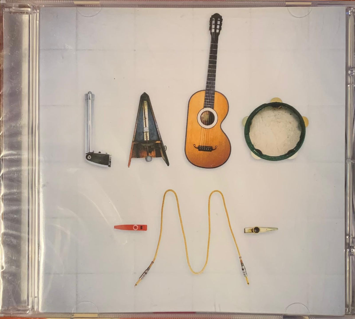 A wooden acoustic guitar with natural finish and black fretboard positioned among musical instruments for labo album cd