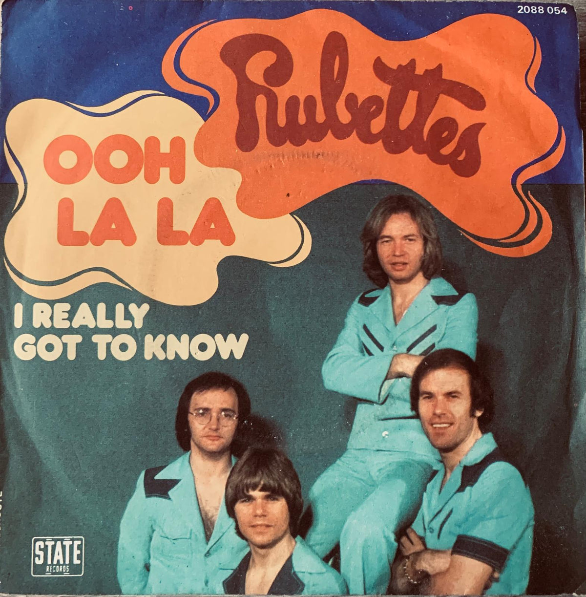 The album cover for Rubettes ooh la la vinyl features the band in matching turquoise suits on a vibrant background