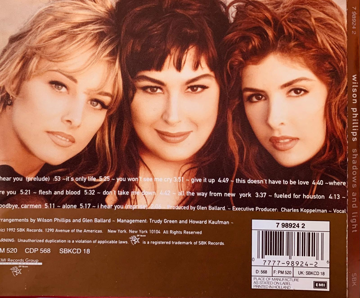 The back cover of the shadows and light album by wilson phillips featuring a sepia-toned photo of the band members