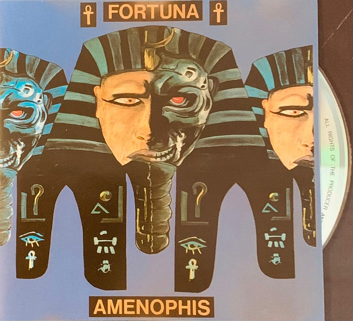 The album cover of fortuna by amenophis features stylized tripartite pharaonic masks with distinct colors and designs