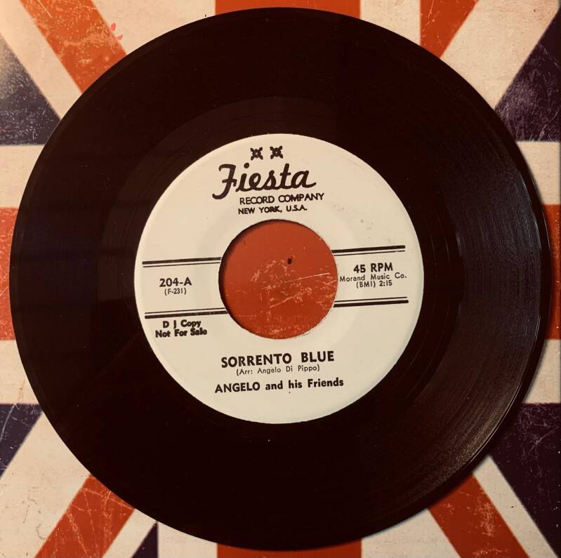 Black 45 rpm vinyl record with white label and orange center from fiesta records for angelo and his friends 1957 promo