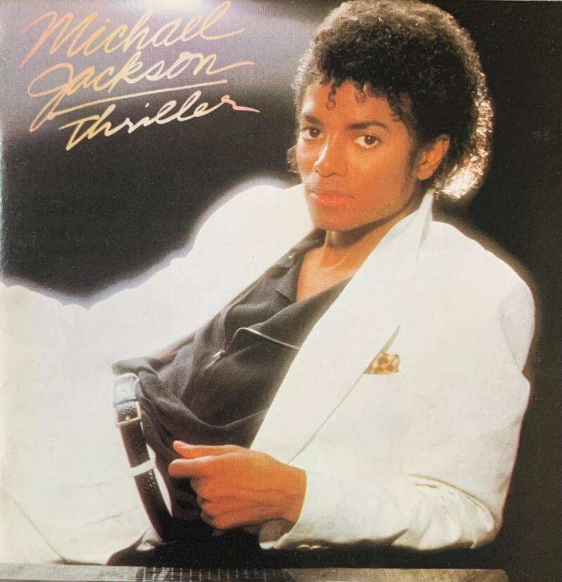 Michael jackson thriller cd cover showing michael jackson in a white suit jacket holding a black belt with silver buckle