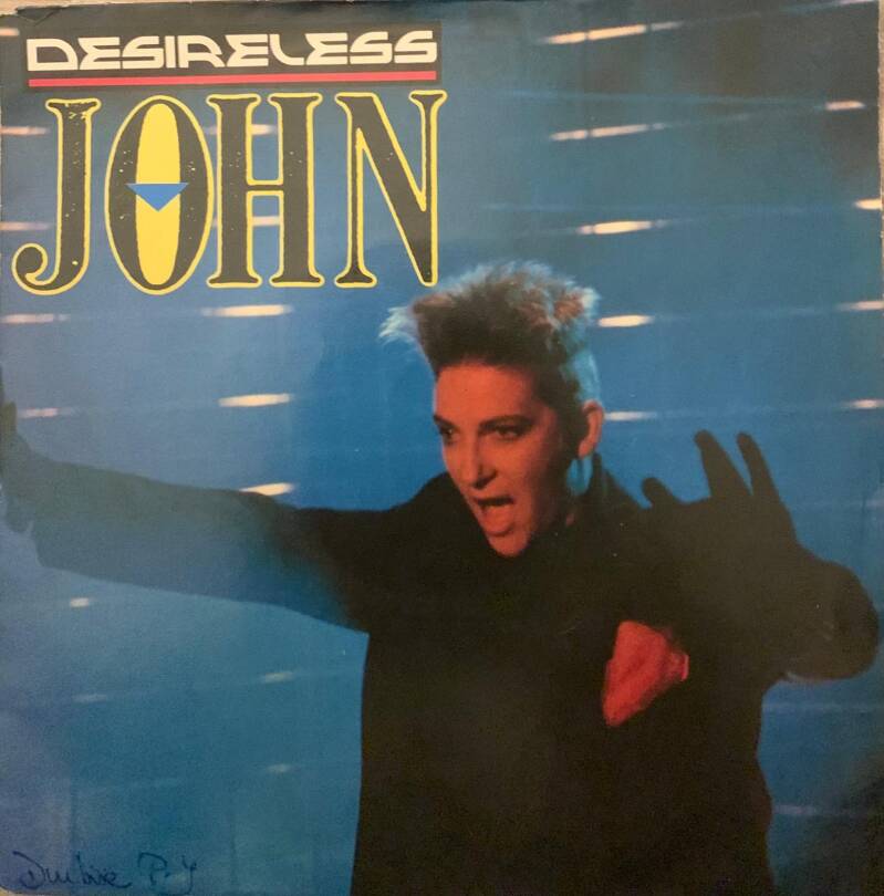 Album cover for desireless by john featuring a stylized portrait with spiky hair and bold makeup on blue background