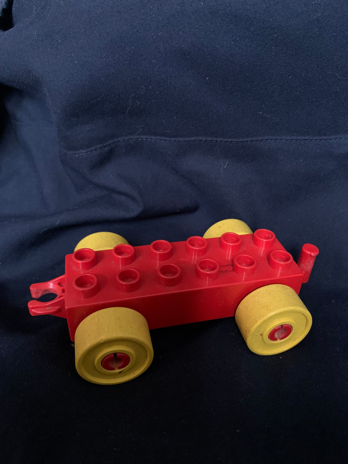 Red plastic duplo toy car with yellow wheels from toys 001 product line for imaginative play