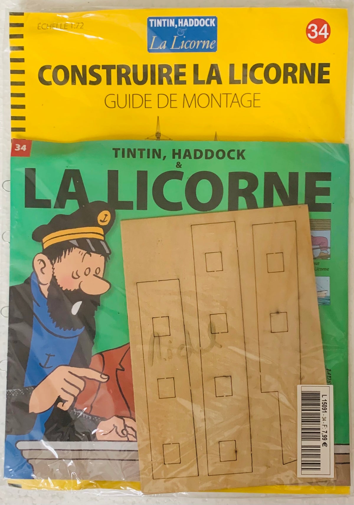 This is a yellow and green cardboard model kit with pre-cut wooden pieces for tintin and haddock la licorne