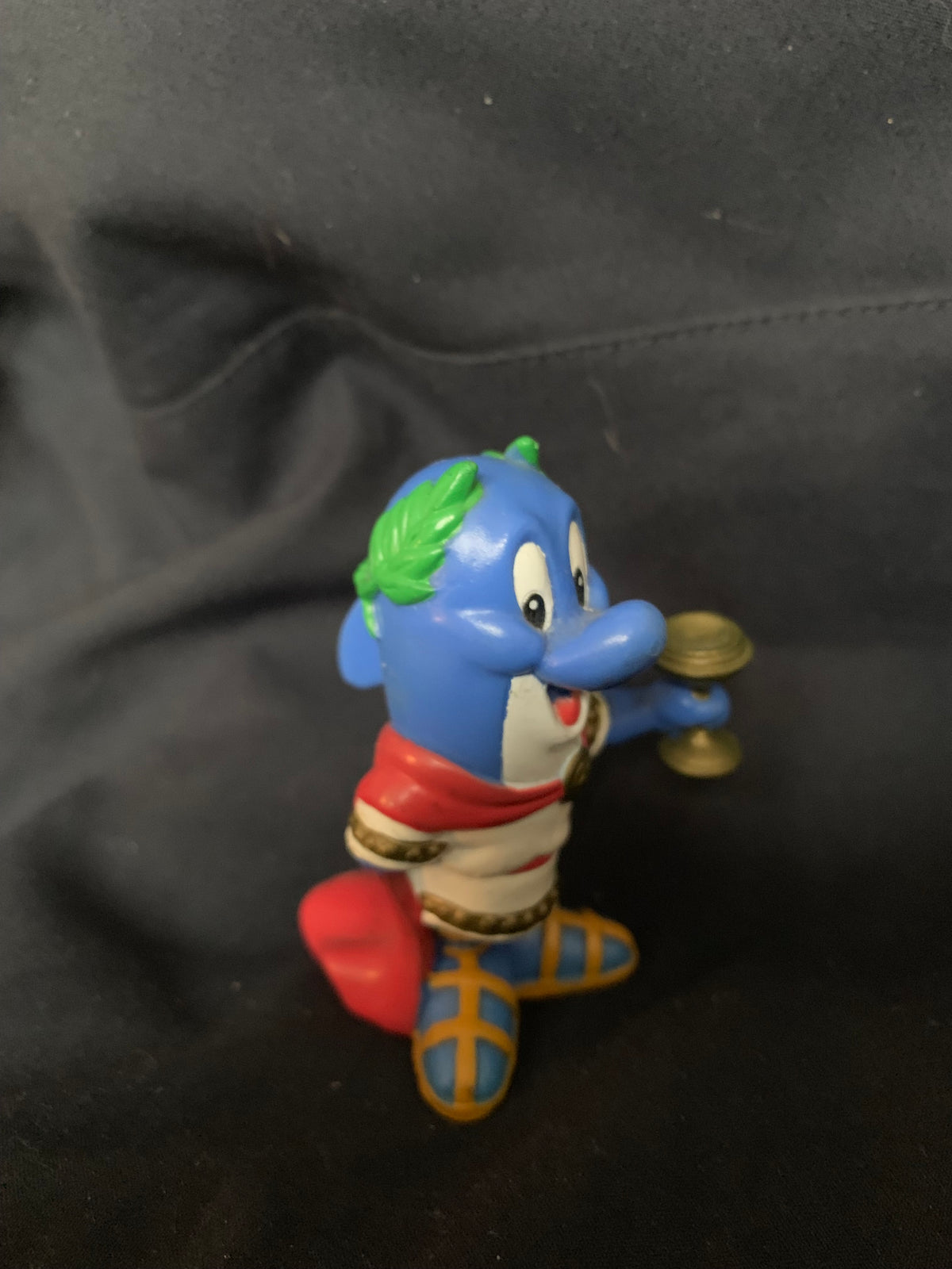 Blue plastic figurine with green leafy hair red scarf and patterned boots holding golden object toys 001 product