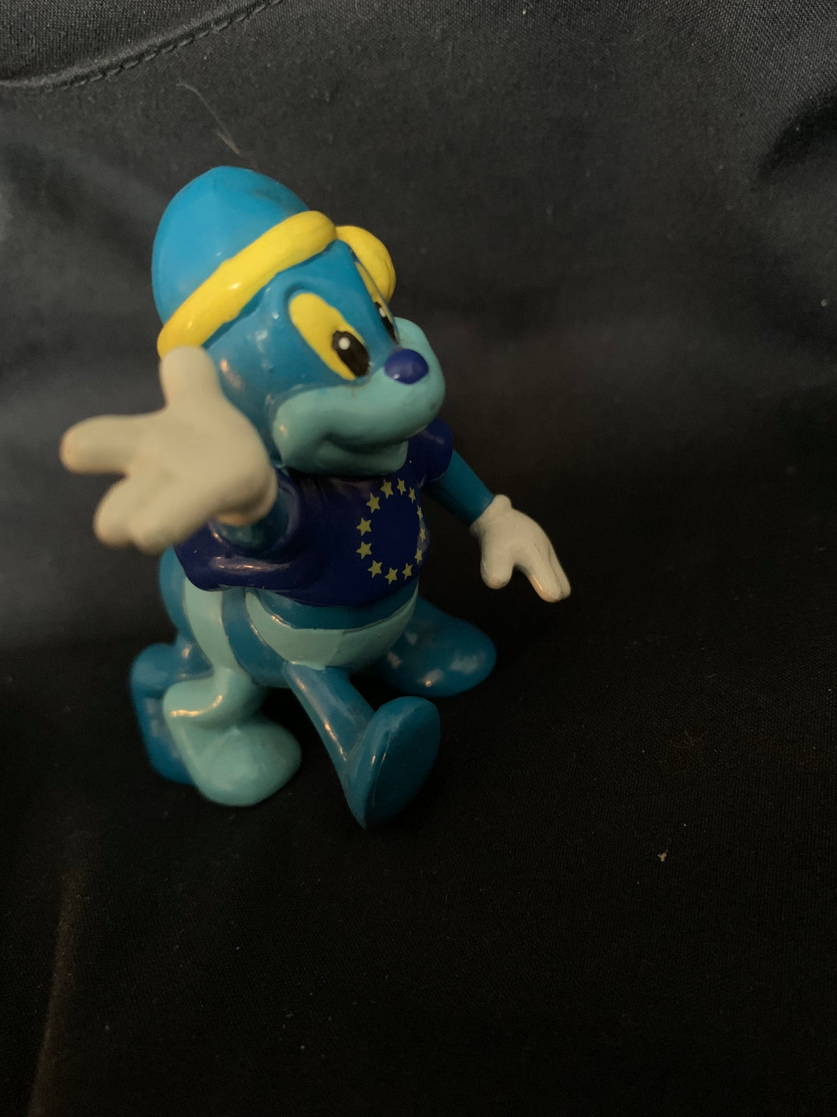 Blue plastic figurine toy wearing a yellow headband and dark blue shirt with white stars from Toys 001 collection