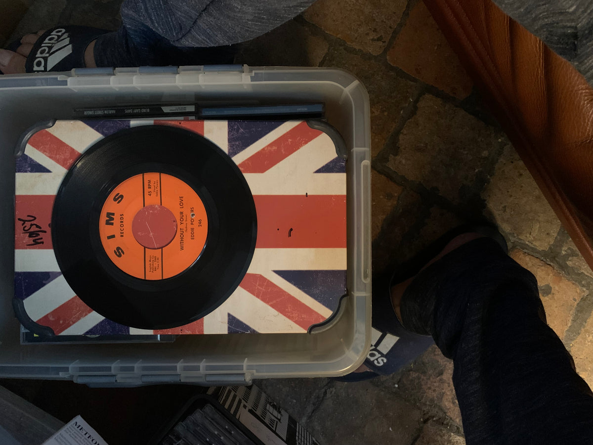 Soul 7 black vinyl record with orange sims records label on union jack surface inside clear storage bin