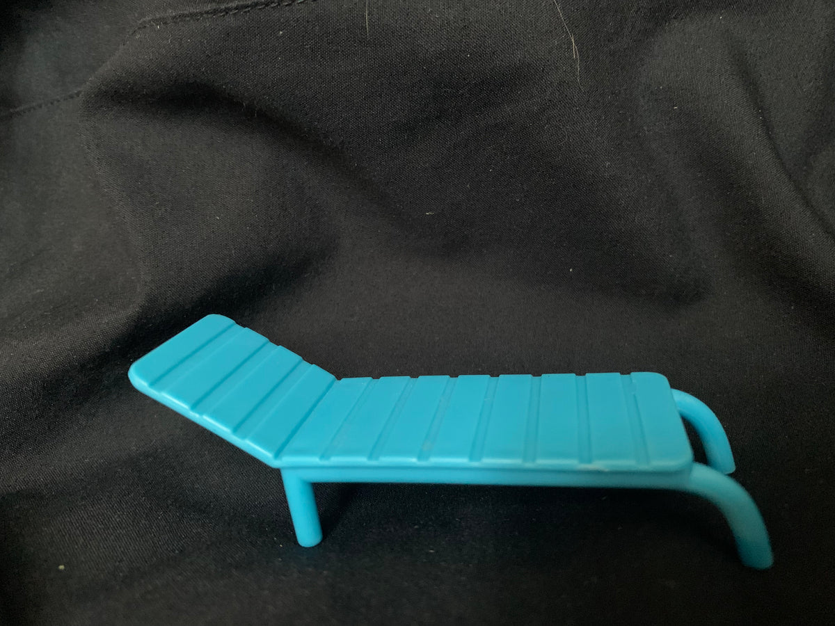 A turquoise plastic lounge chair with slatted design and curved armrests in toys 001 collection