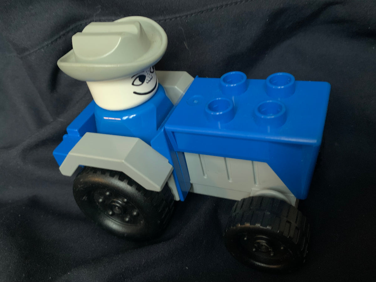 Blue and gray lego duplo truck with a smiling cowboy figure wearing a light gray hat from toys 001