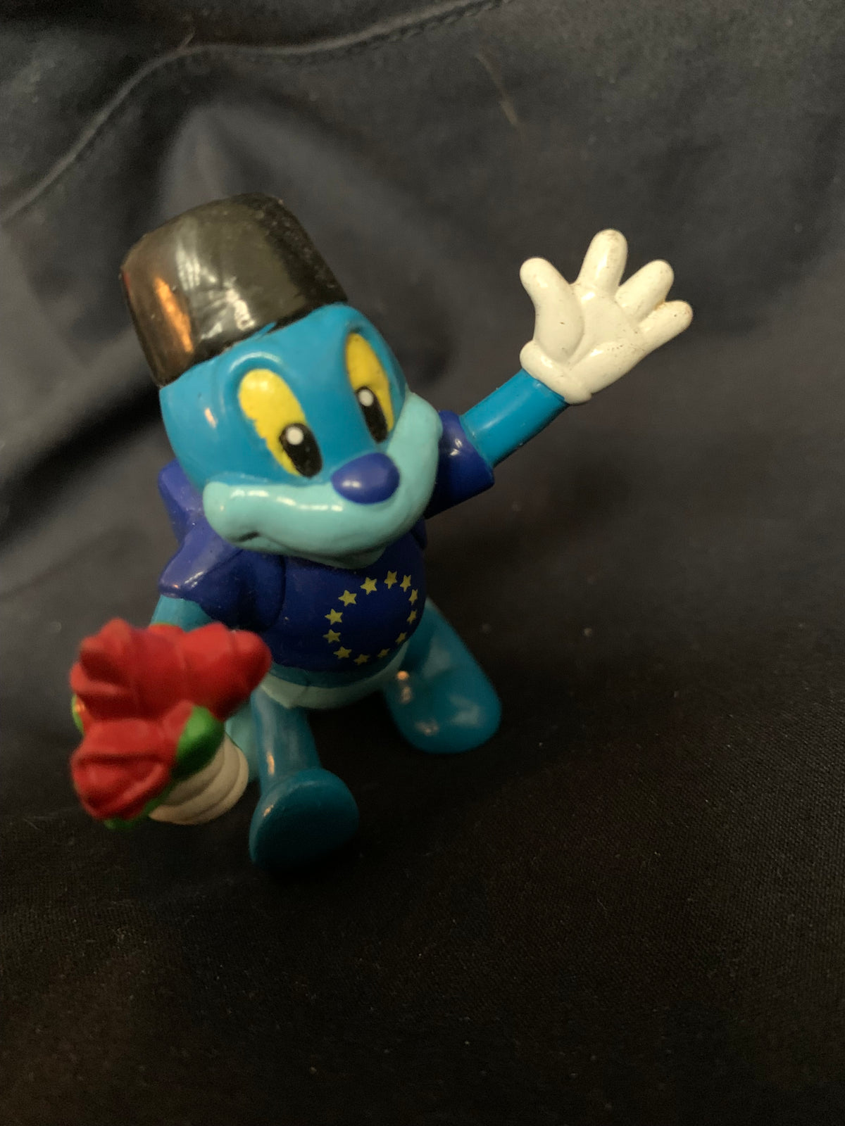 Blue plastic figurine toy wearing a black hat and holding a red rose from toys 001 collection