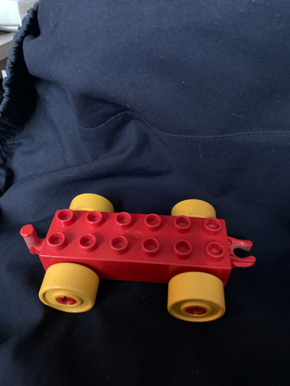 Red plastic toy car with yellow wheels and classic lego design from toys 001 collection