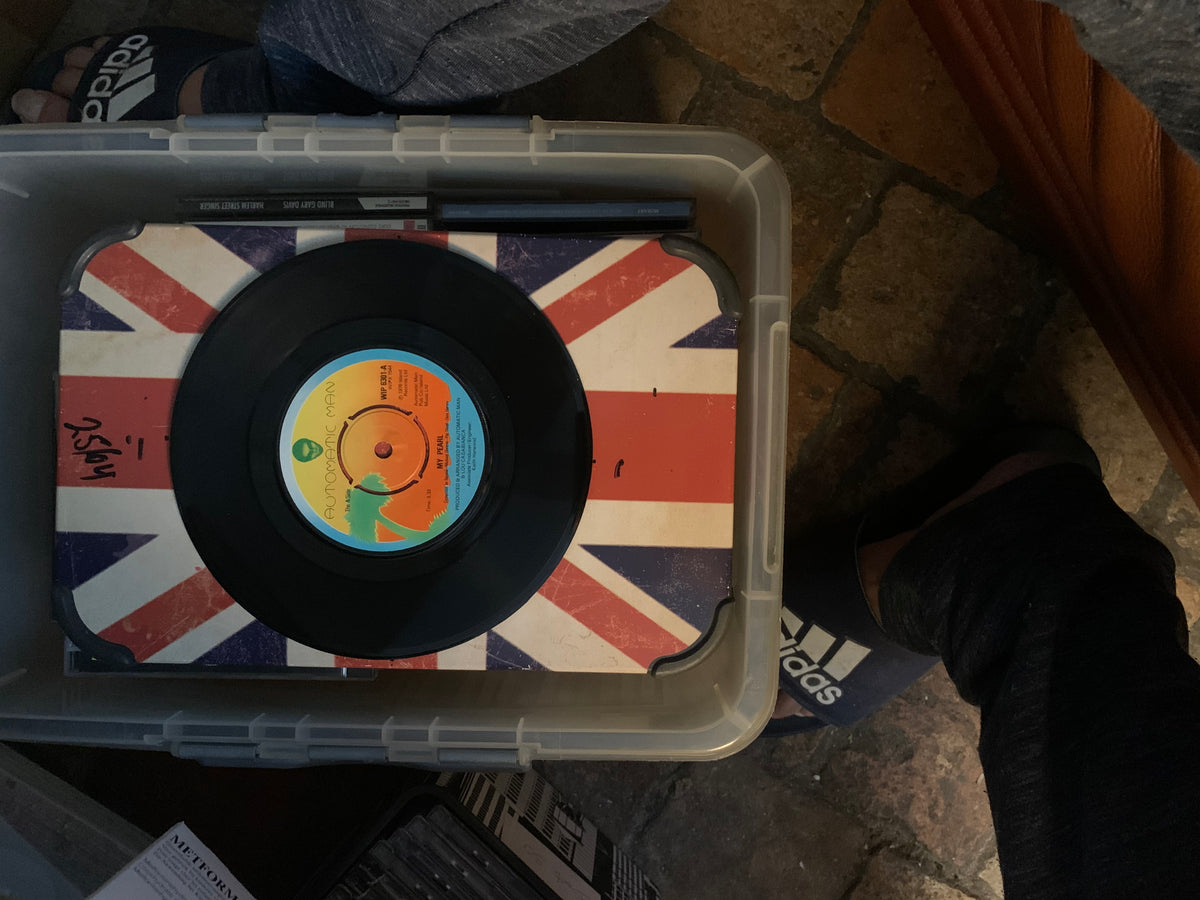 Black vinyl soul 7 record with a colorful orange yellow blue label resting on a union jack surface