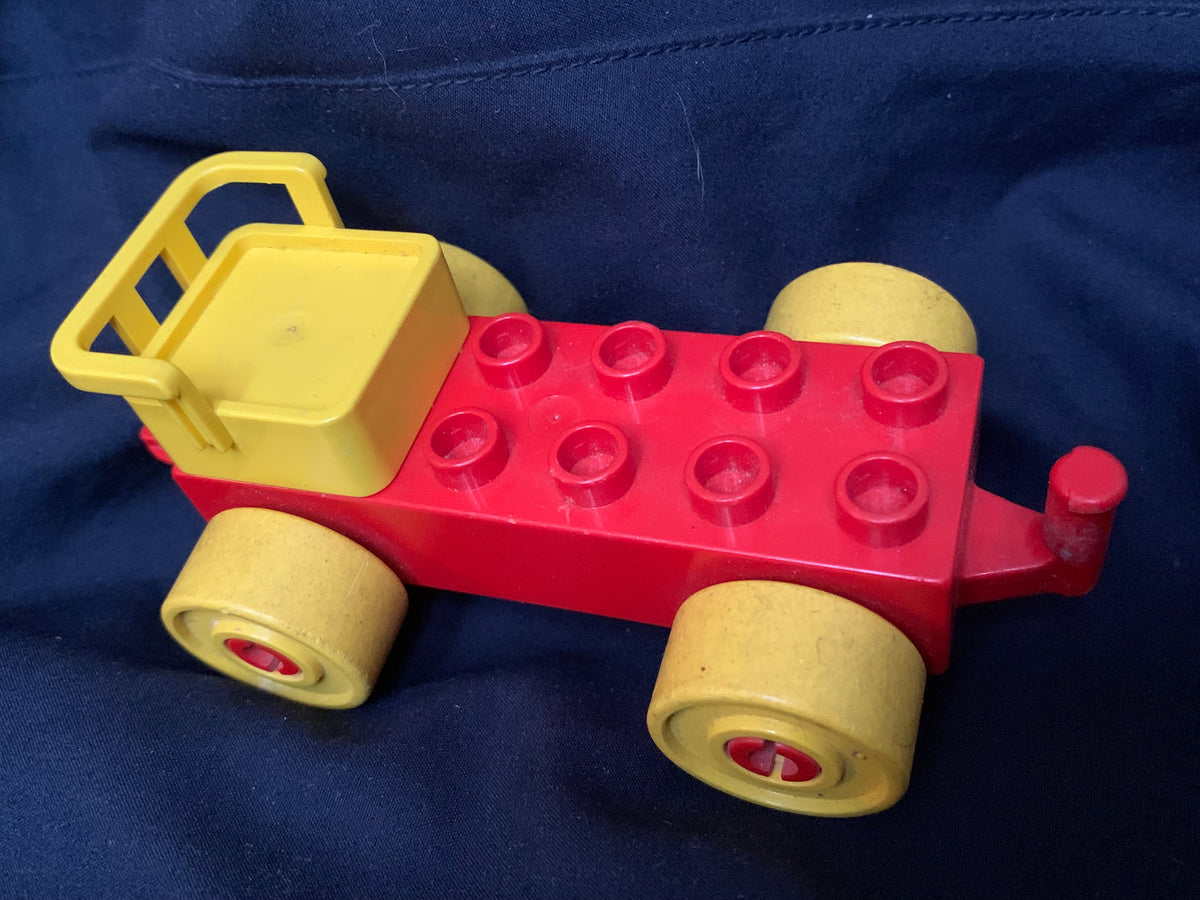 Red and yellow plastic toy truck with four wheels and classic lego style brick design in toys 001 product