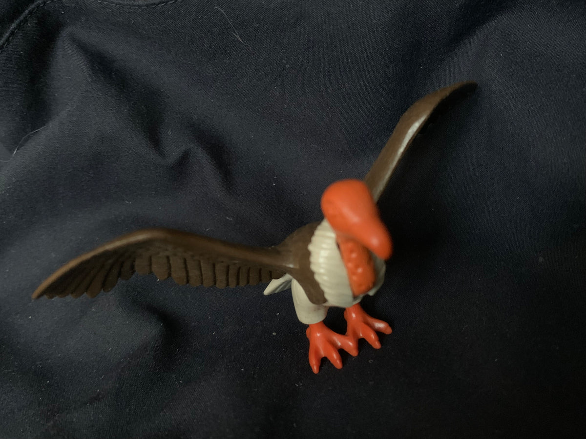 A plastic toy vulture with bright orange head beak and feet brown segmented wings and white underbelly toys 001