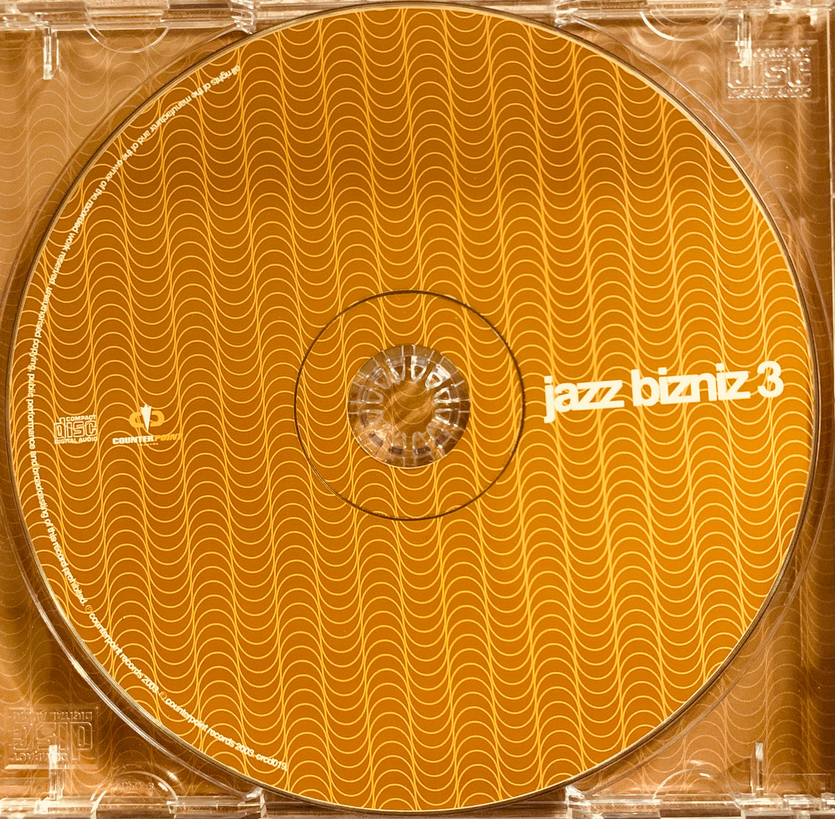 Orange cd with a wavy pattern and white text jazz bizniz 3 labeled as cd 001 product