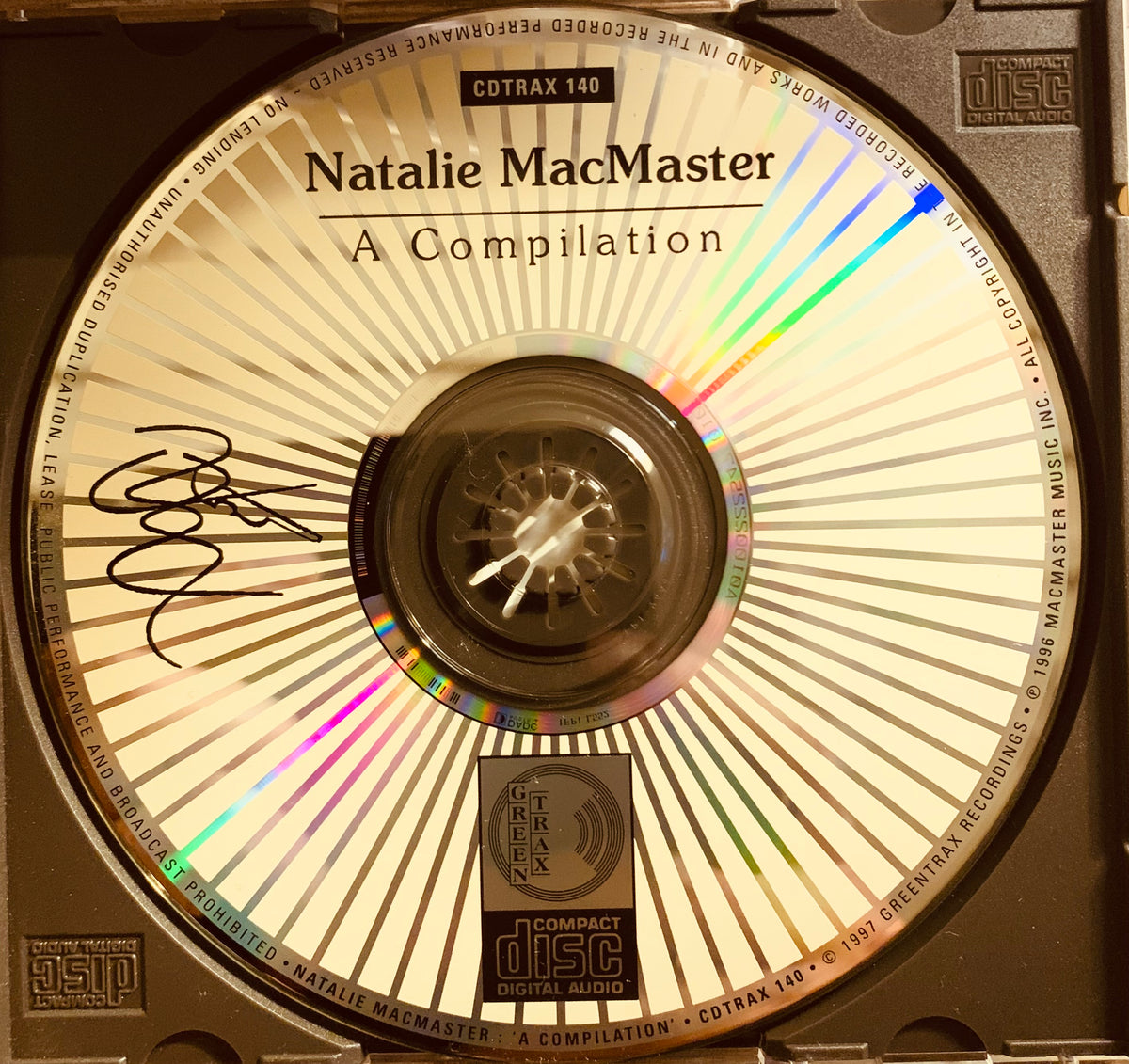 A signed compact disc with beige and silver sunburst design titled natalie macmaster a compilation by greentrax records