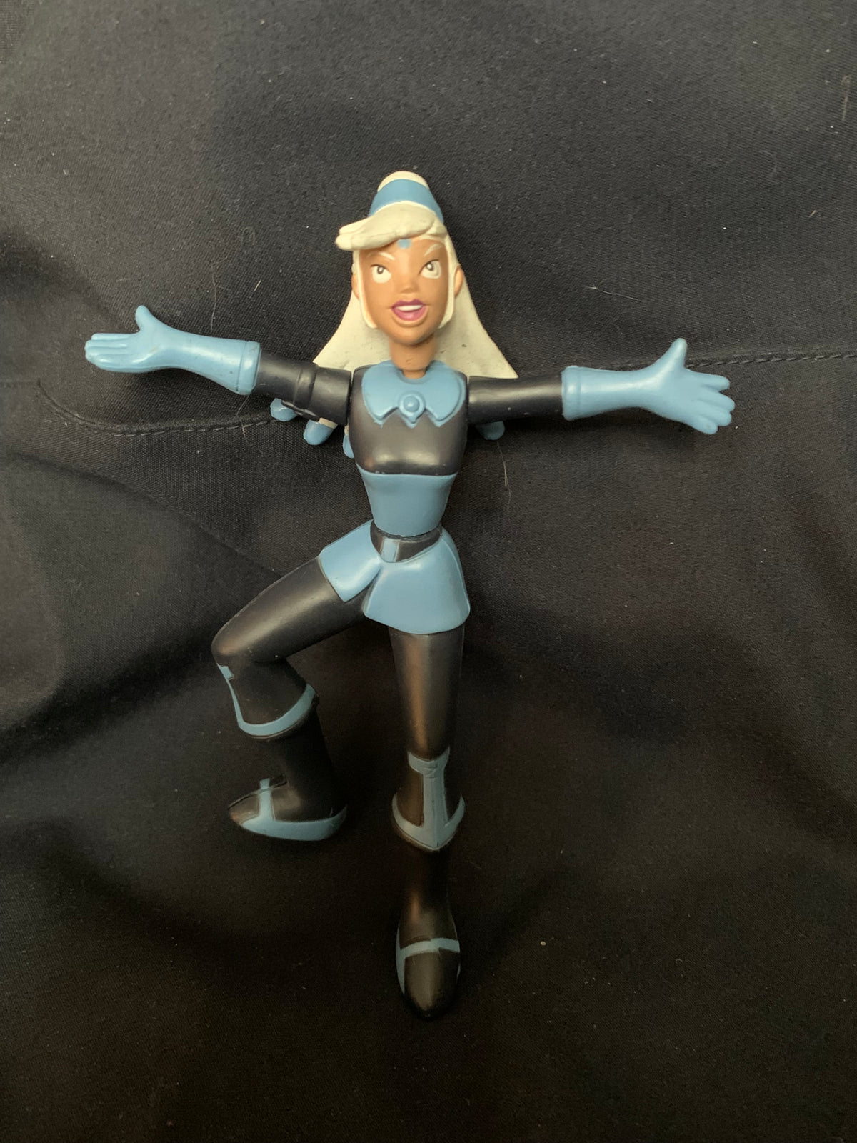 A blue and black plastic figurine of a female character with blonde hair in a futuristic outfit toys 001