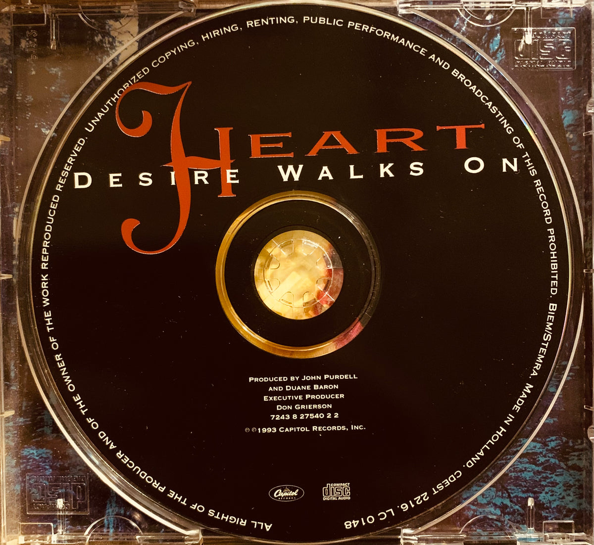 Black cd with orange and gold lettering of the album desire walks on by heart in product cd 001