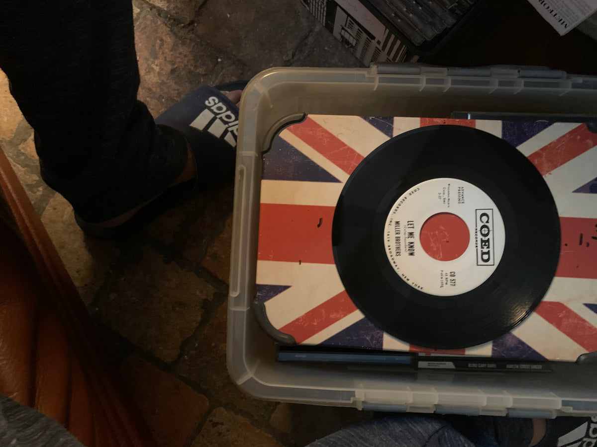 Black vinyl record with white label and red and black text on union jack surface inside clear plastic container for soul 7