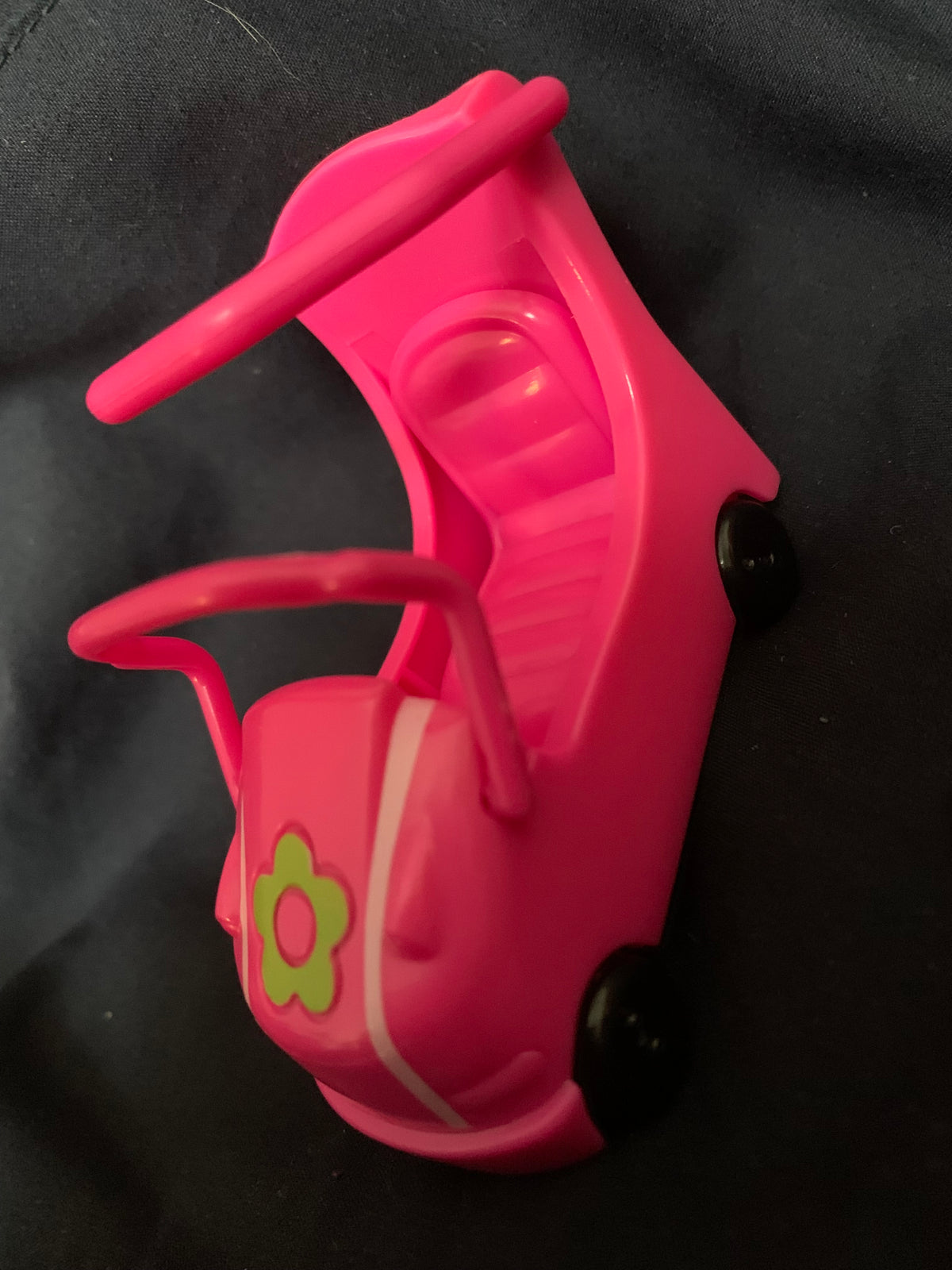 A bright pink plastic toy car with black wheels and a green flower decal from toys 001 collection