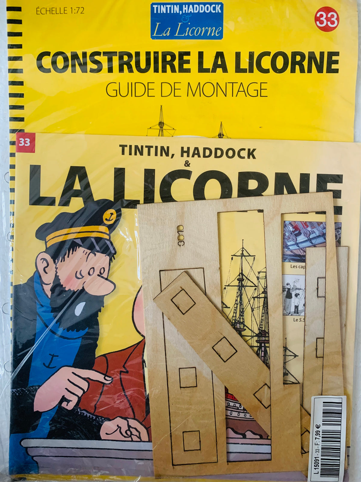 Yellow cardboard model kit la licorne ship from tintin with pre-cut wooden pieces and printed outlines for building