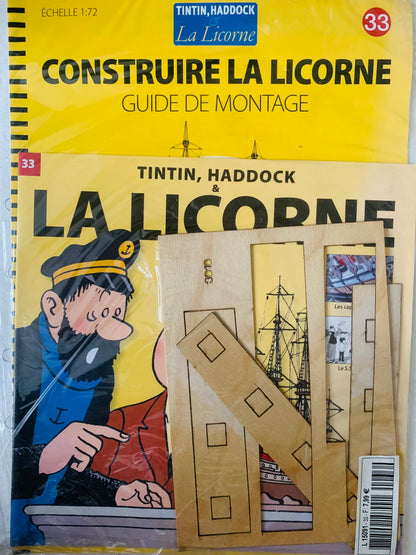 Yellow cardboard model kit la licorne ship from tintin with pre-cut wooden pieces and printed outlines for building