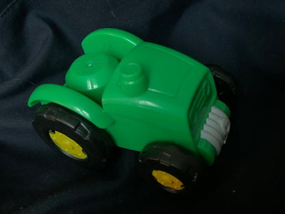 Bright green plastic toy tractor with black tires and yellow rims in toys 001 product image