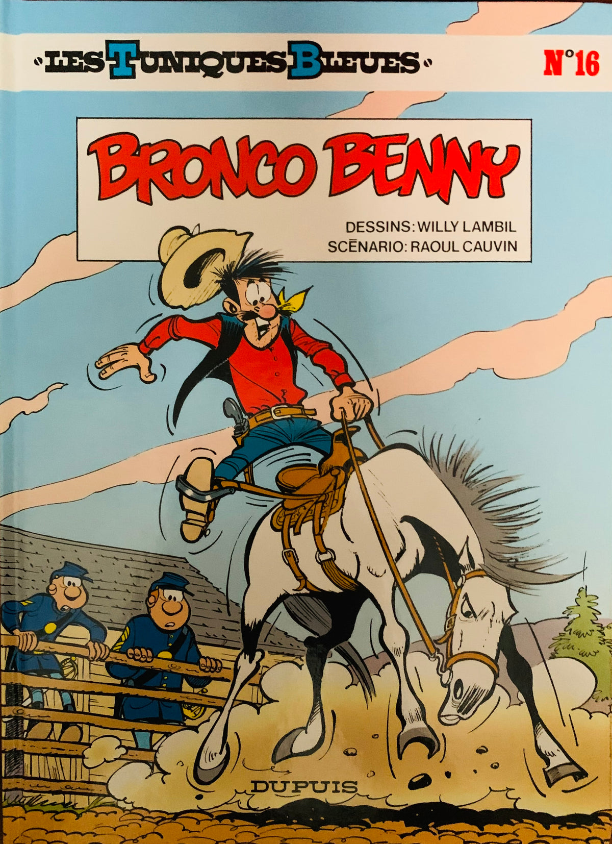 The cover of bronco benny comic book from les tuniques bleues shows a cowboy in red shirt riding a white horse