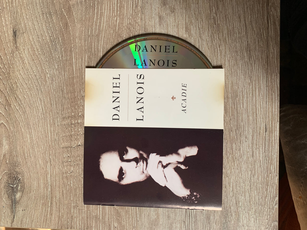Cd 001 featuring daniel lanois acadie album cover with black and white portrait on cream and dark gray design