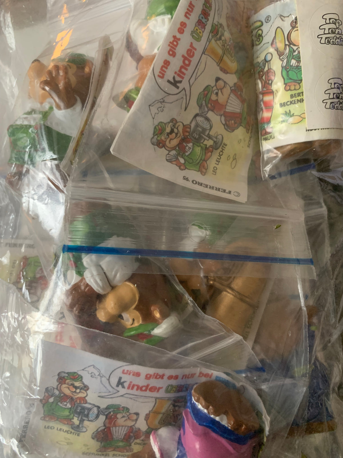 Plastic dragon figurines in clear packaging with colorful cartoon character cards from kinder surprise toy set