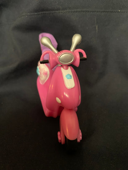 Pink plastic scooter toy with silver handlebars and white panel featuring a blue cloud design from toys 001