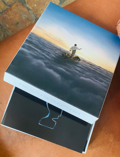 Punk floyd endless summer box set featuring pink floyd the endless river with a serene lone figure in a boat on clouds at sunset