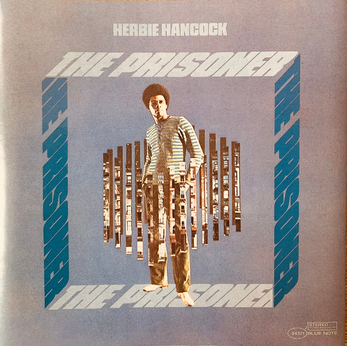 Herbie hancock the prisoner vinyl album cover showing a man with afro behind cassette tape bars on blue background cd 001