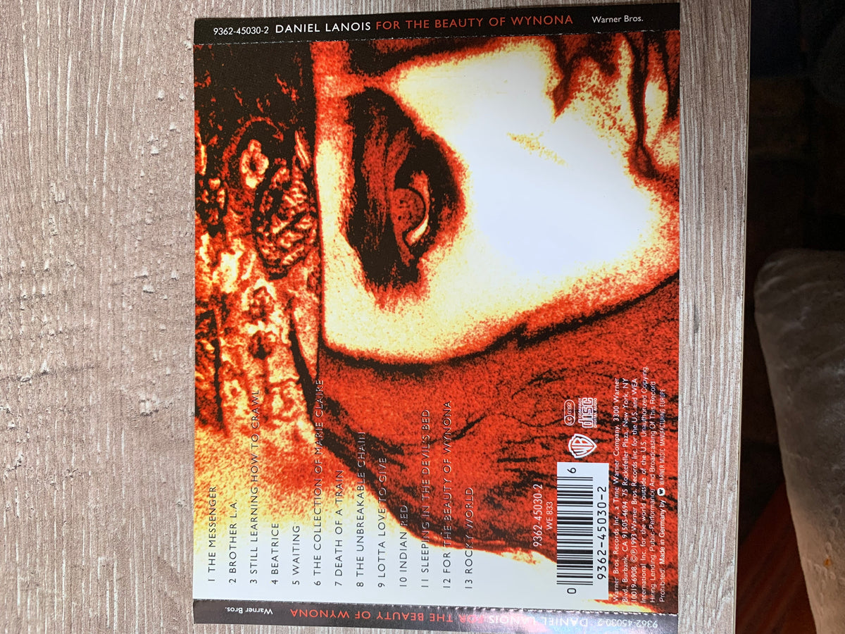 The back cover of daniel lanois’s cd for the beauty of wynona features a fiery textured close-up in red orange and white tones