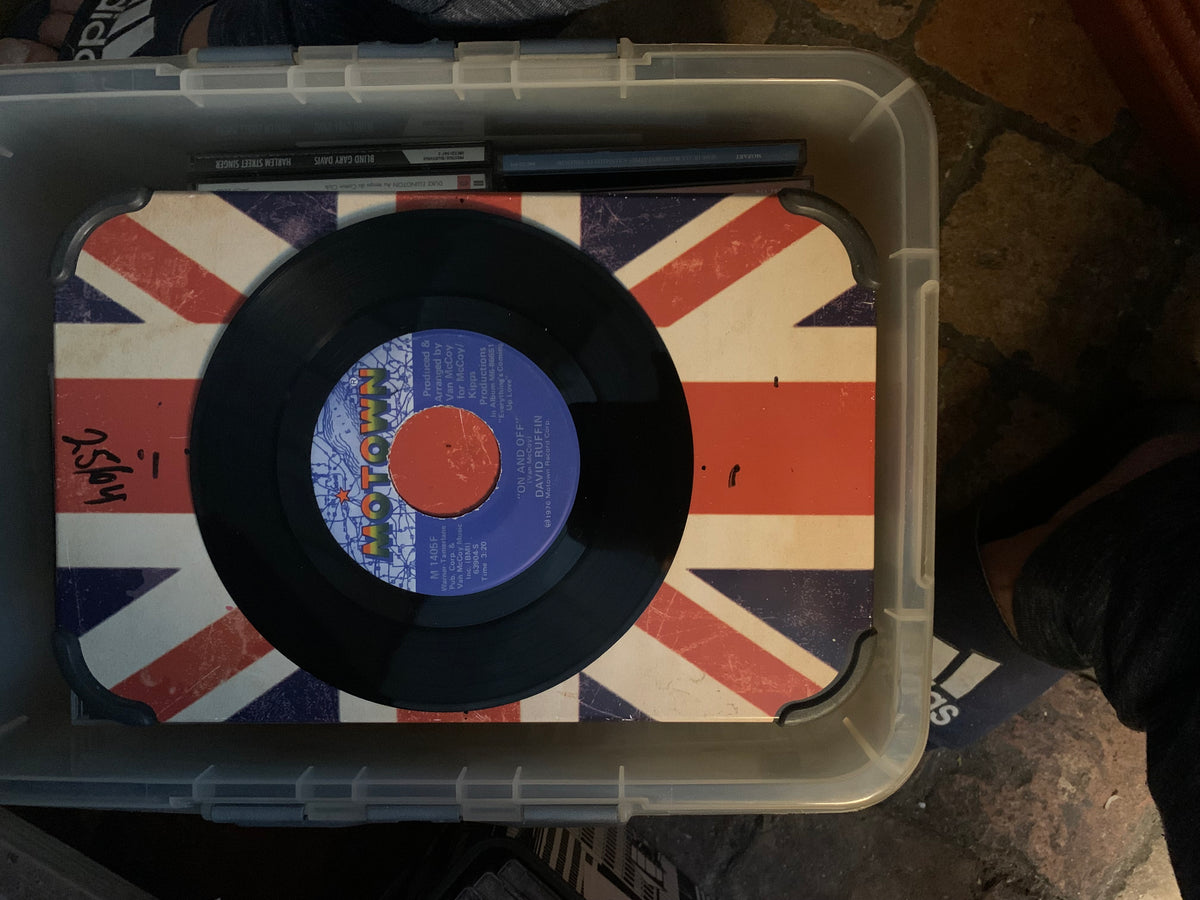 Black vinyl soul 7 record with blue and orange motown label resting on a union jack surface