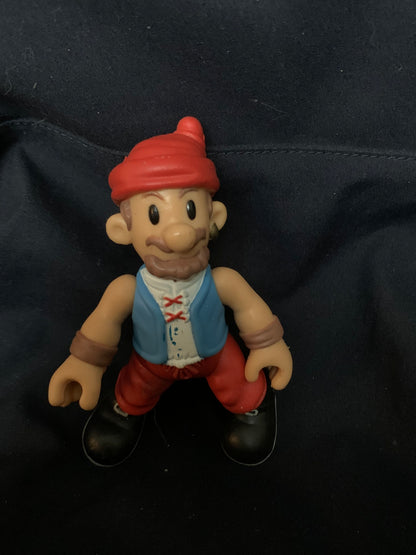 A plastic figurine of a cartoonish pirate with a red hat blue vest white shirt and red pants from Toys 001