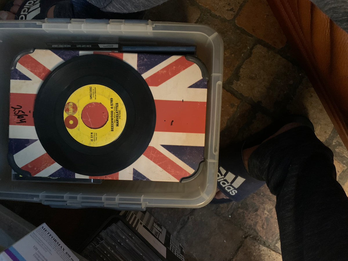 Black vinyl soul 7 inch record with yellow label featuring red and white text on union jack surface inside plastic bin