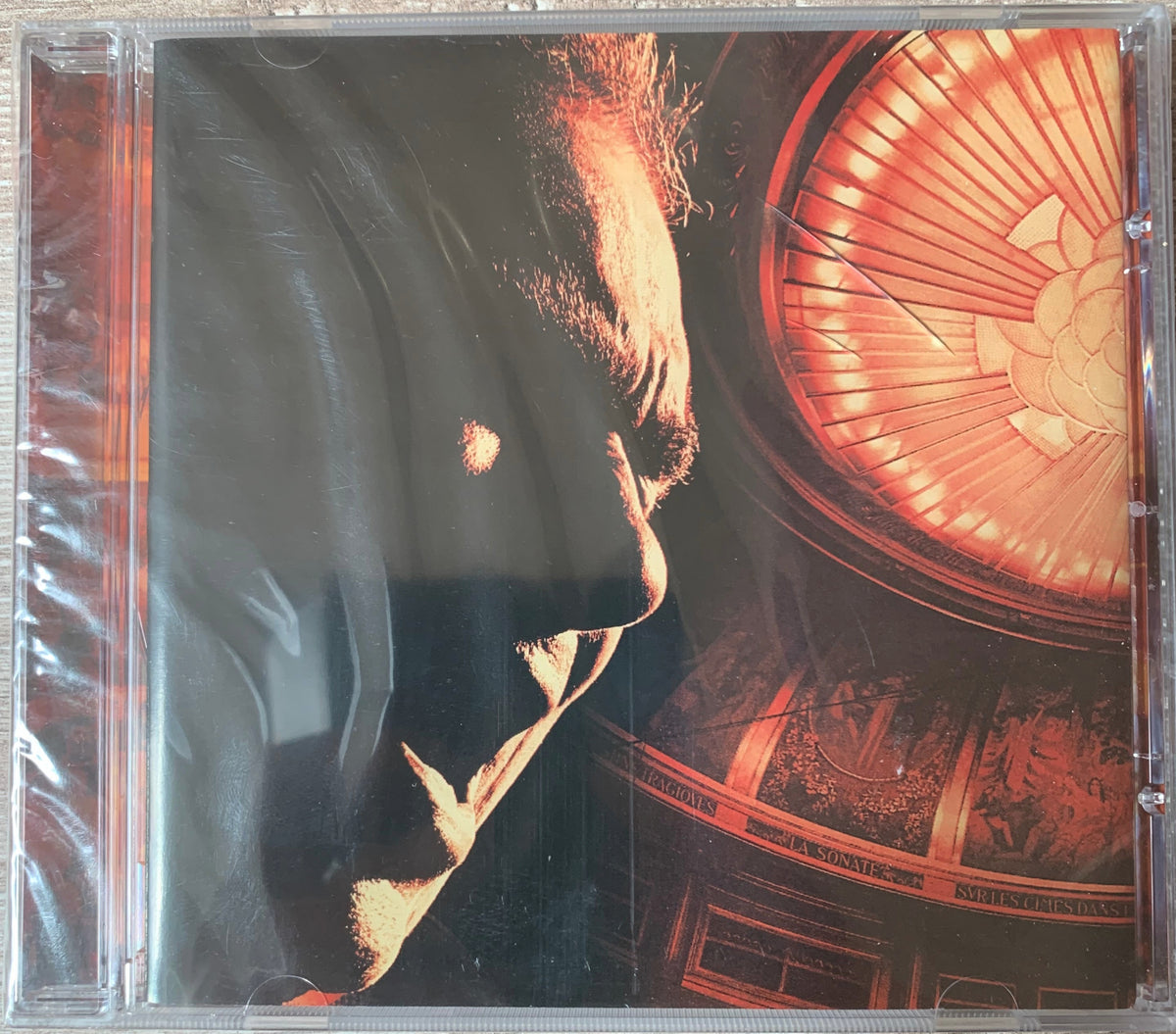 Cd 001 cd case featuring album art with a mans profile against an ornate warmly lit architectural interior