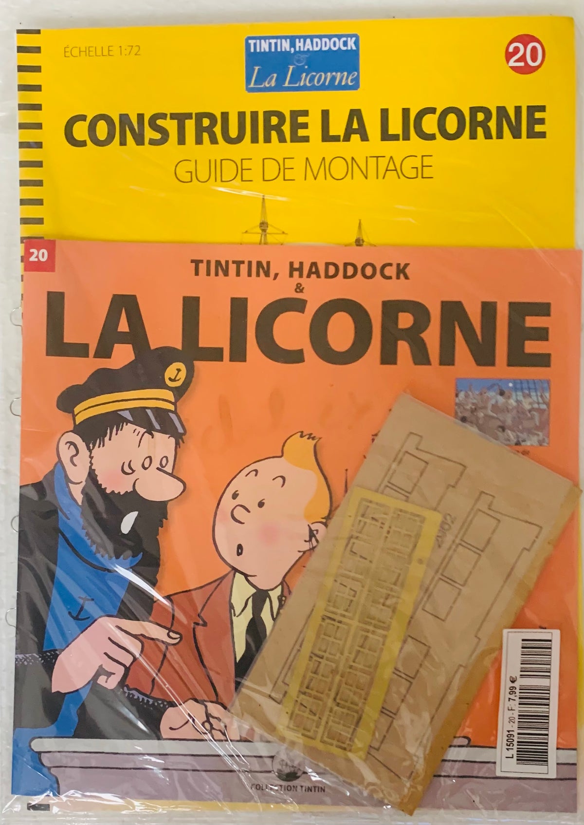 Yellow and orange plastic-wrapped model kit guide for tintin and haddock ship la licorne with illustrated characters and assembly instructions