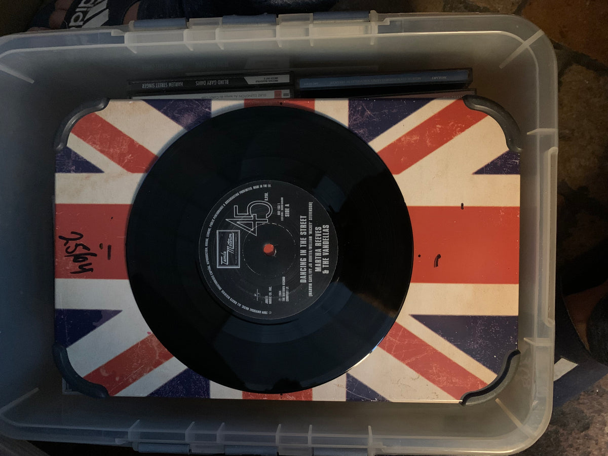 Soul 7 black 45 rpm vinyl record with white label and red center hole on union jack mat inside clear plastic bin