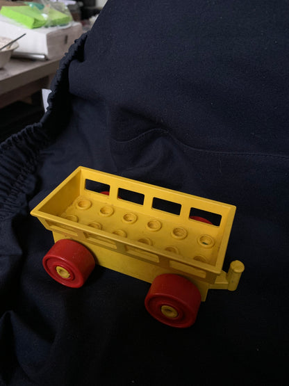 Yellow plastic toy wagon with red wheels and grid-like bed design for carrying toys in Toys 001 product line