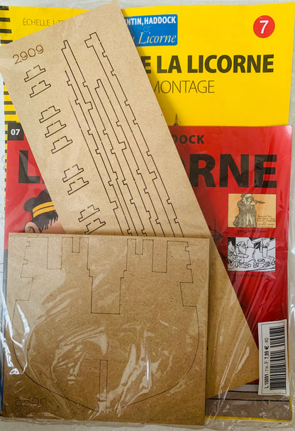 Brown cardboard model ship kit pieces in clear plastic packaging for la licorne assembly and crafting project