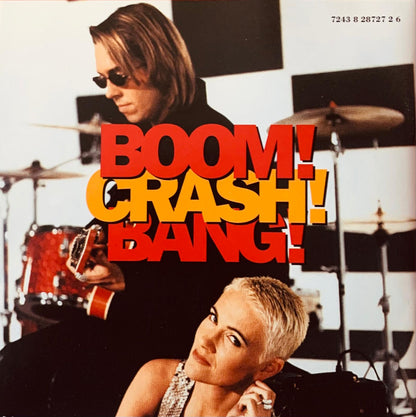 The album cover for boom Crash Bang features bold red and yellow lettering over a black and white checkered background