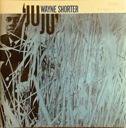 Wayne shorter juju cd 001 album cover with black and white photo of artist partially obscured by tall grass on beige background