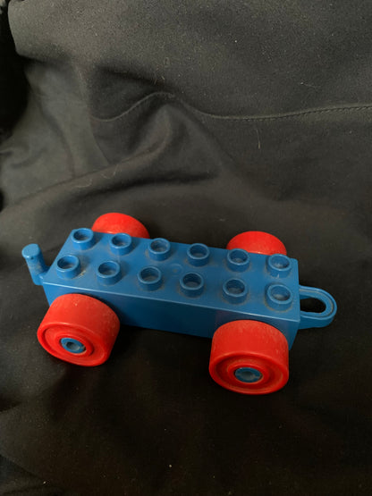 Blue plastic toy car with red wheels and a side handle from the toys 001 collection